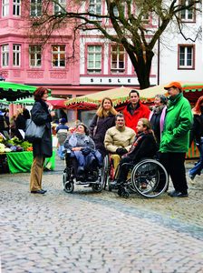 Eine Touristengruppe mit Rollstuhlfahrenden auf dem Leichhof