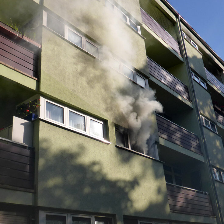 يتصاعد الدخان من الشقة المشتعلة بالنيران.