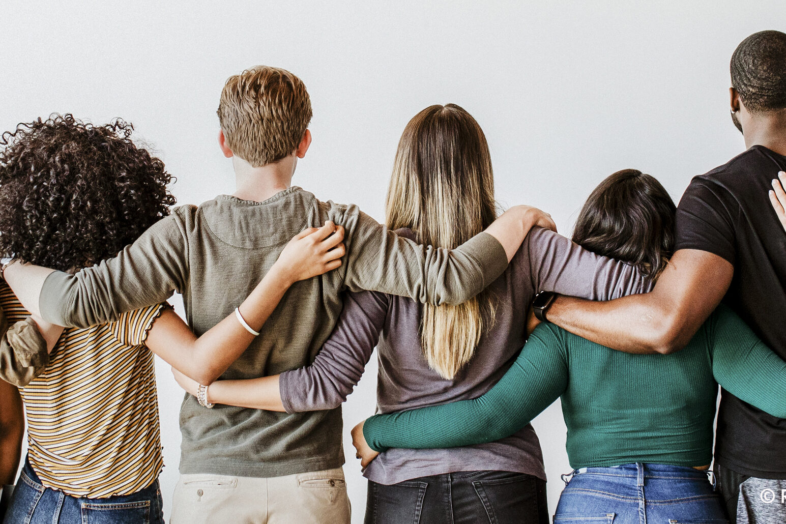 Menschenkette: 9 Menschen halten sich in den Armen, zu sehen sind die Hinterköpfe und Rücken
