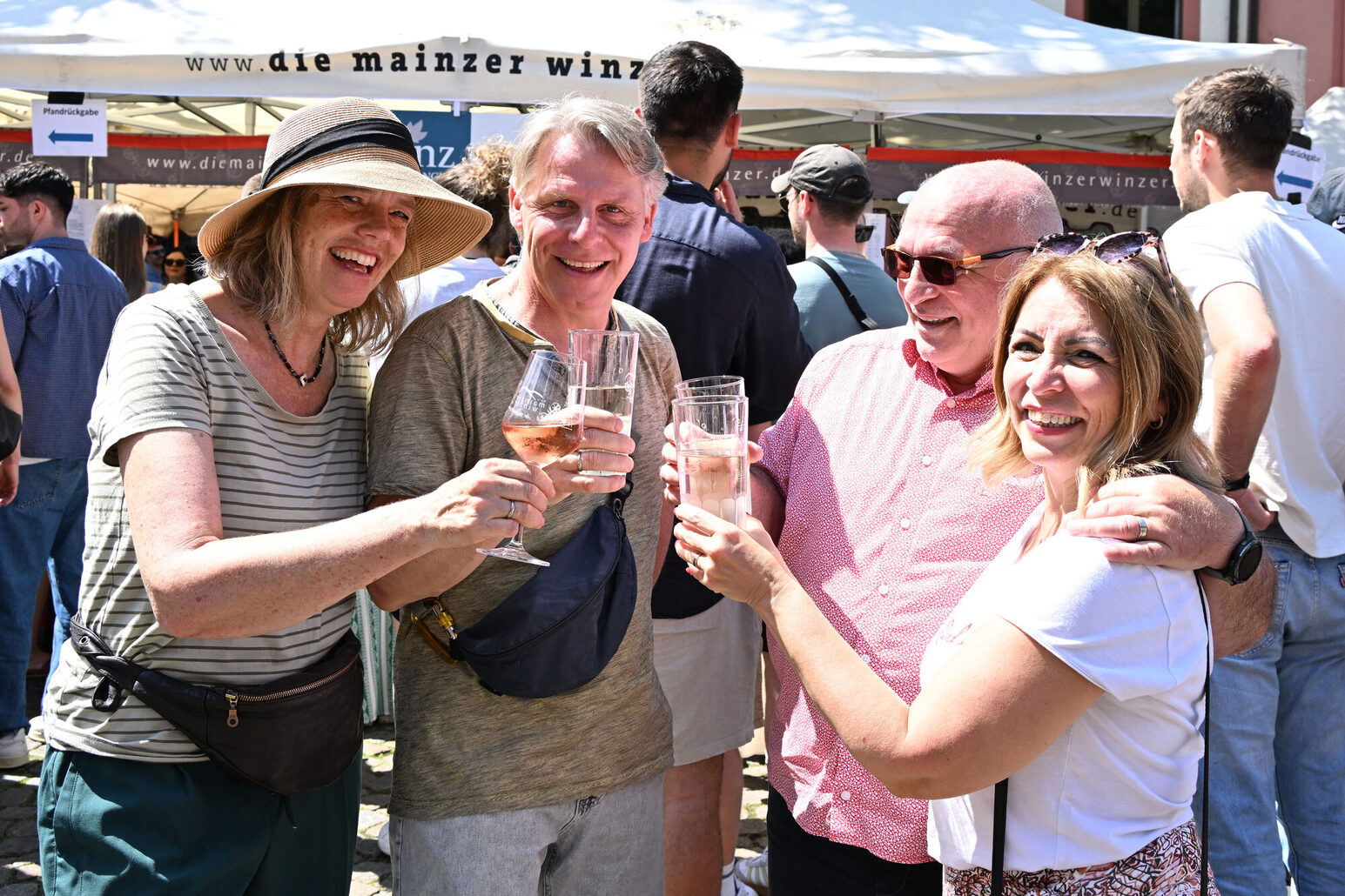 Zwei Frauen und zwei Männer stoßen auf dem Mainzer Marktfrühstück auf dem Leichhof an.
