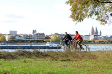 Radfahrer auf der Maaraue, die Mainzer Stadtsilhouette im Hintergrund