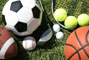 Bälle unterschiedlicher Sportarten auf dem Rasen. © AdobeStock/JJAVA