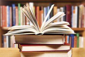Bücherstapel mit einem aufgeschlagenen Buch © Fotolia