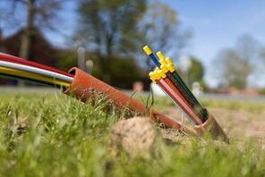 Glasfaserkabel ragen aus dem Boden &copy; AdobeStock / Christian Schwier