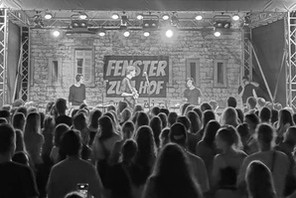Eine Bühne mit Musikern und Publikum im Dunklen. © Musikmaschine Mainz