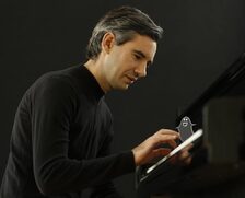 Ein Mann am Klavier spricht mit dem kleinen Geist.