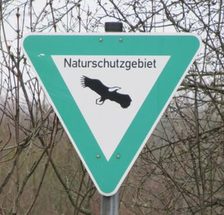 Auf dem Foto ist ein Naturschutzgebiet-Schild abgebildet.
