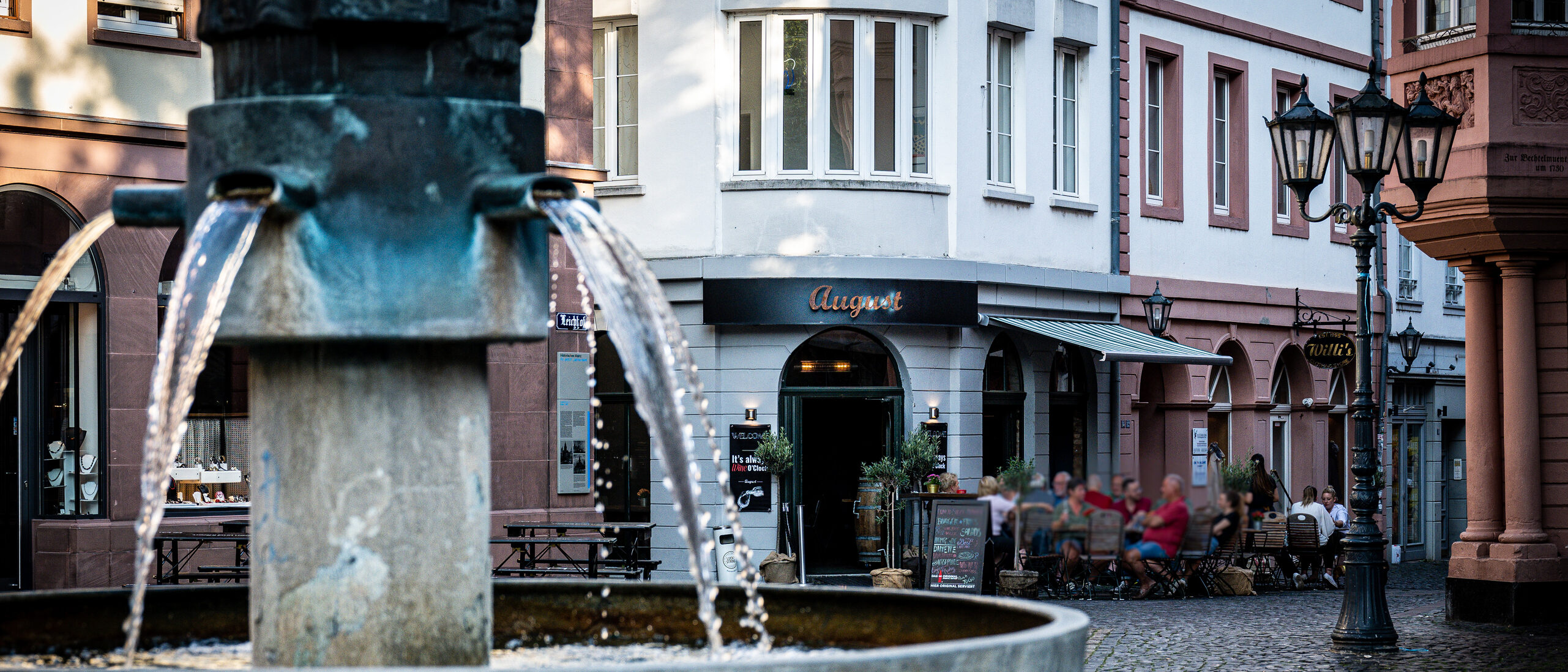 Leichhof-Brunnen in der Altstadt, im Hintergrund ein Restaurant und Geschäfte