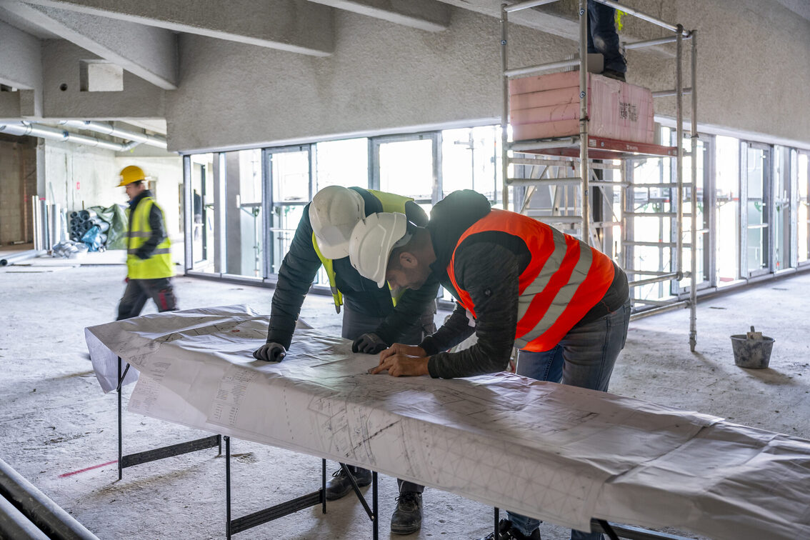 Operai all'interno del cantiere, osservano il progetto.