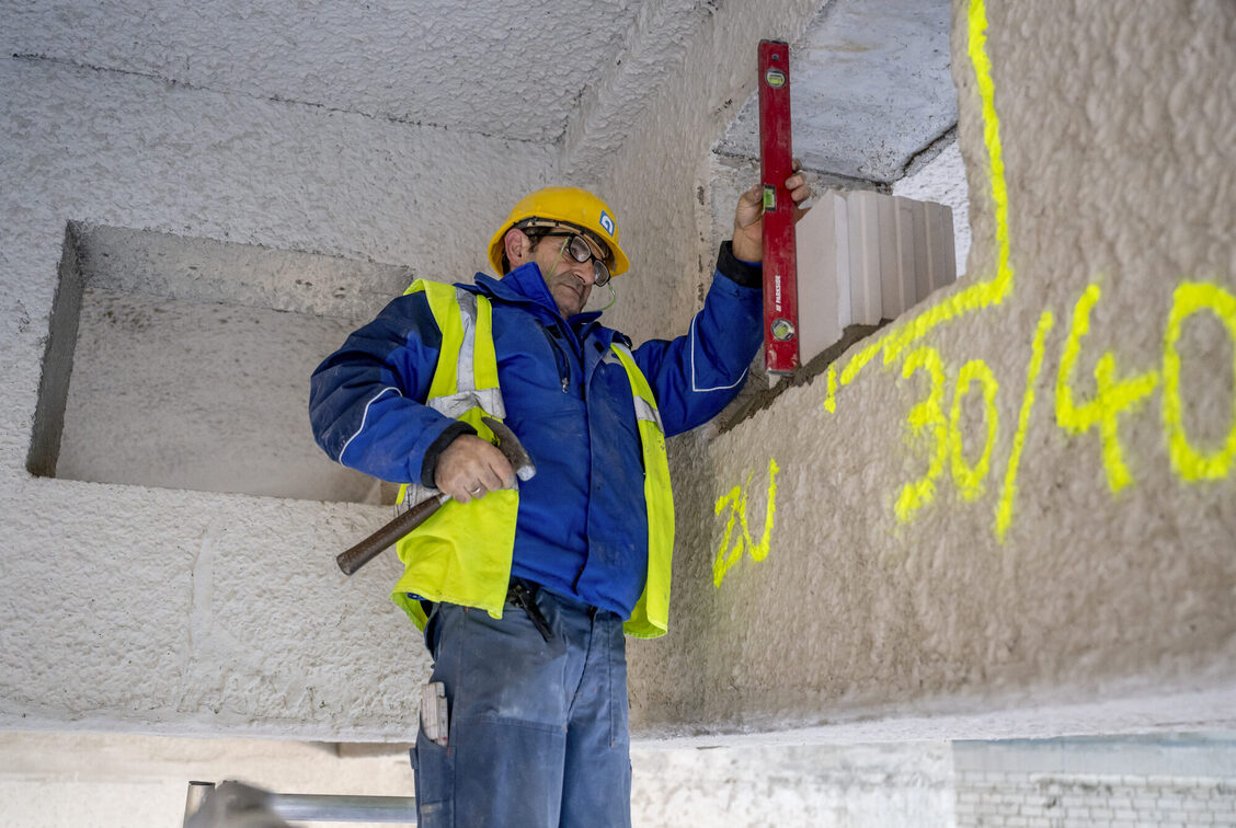 Un operaio edile all'interno con una livella.
