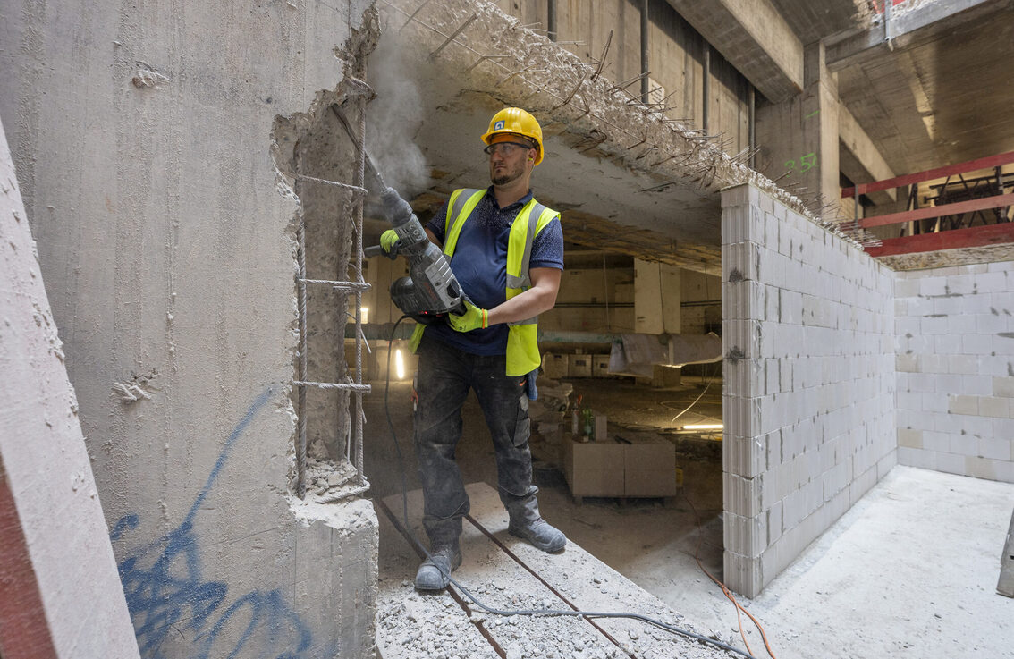 Un operaio edile rimuove il cemento.