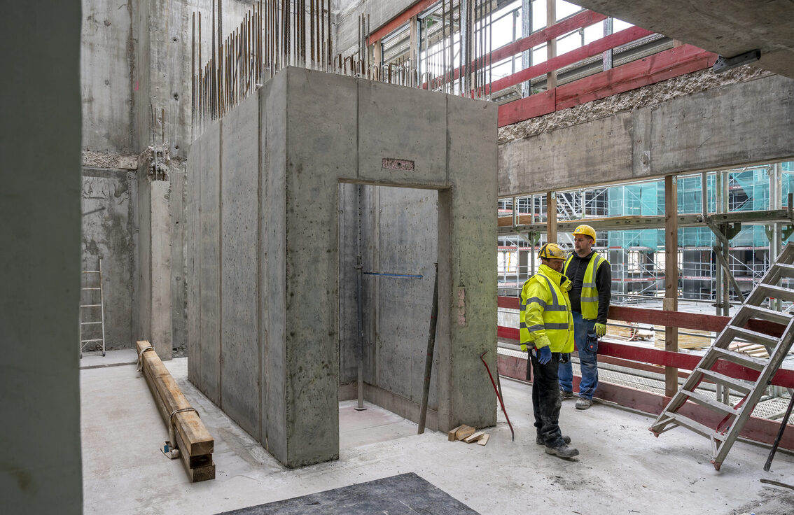 Due operai edili in piedi nel cantiere del municipio.