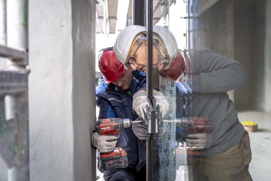 I lavoratori edili inseriscono i vetri delle finestre.