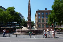 Bildergalerie Neubrunnen Neubrunnenplatz mit Neubrunnen Weithin sichtbares Merkmal des Brunnens ist sein circa 12 Meter hoher Obelisk. Am Fuße des Obelisken sitzen die aus Muschelkalk gefertigten Flussgötter, die Rhein und Main symbolisieren und 1726 von Franz Matthias Hiernle geschaffen wurden. Hierbei handelt es sich heute um Kopien des Jahres 1877. Seitdem sind die Originale im Landesmuseum Mainz ausgestellt.