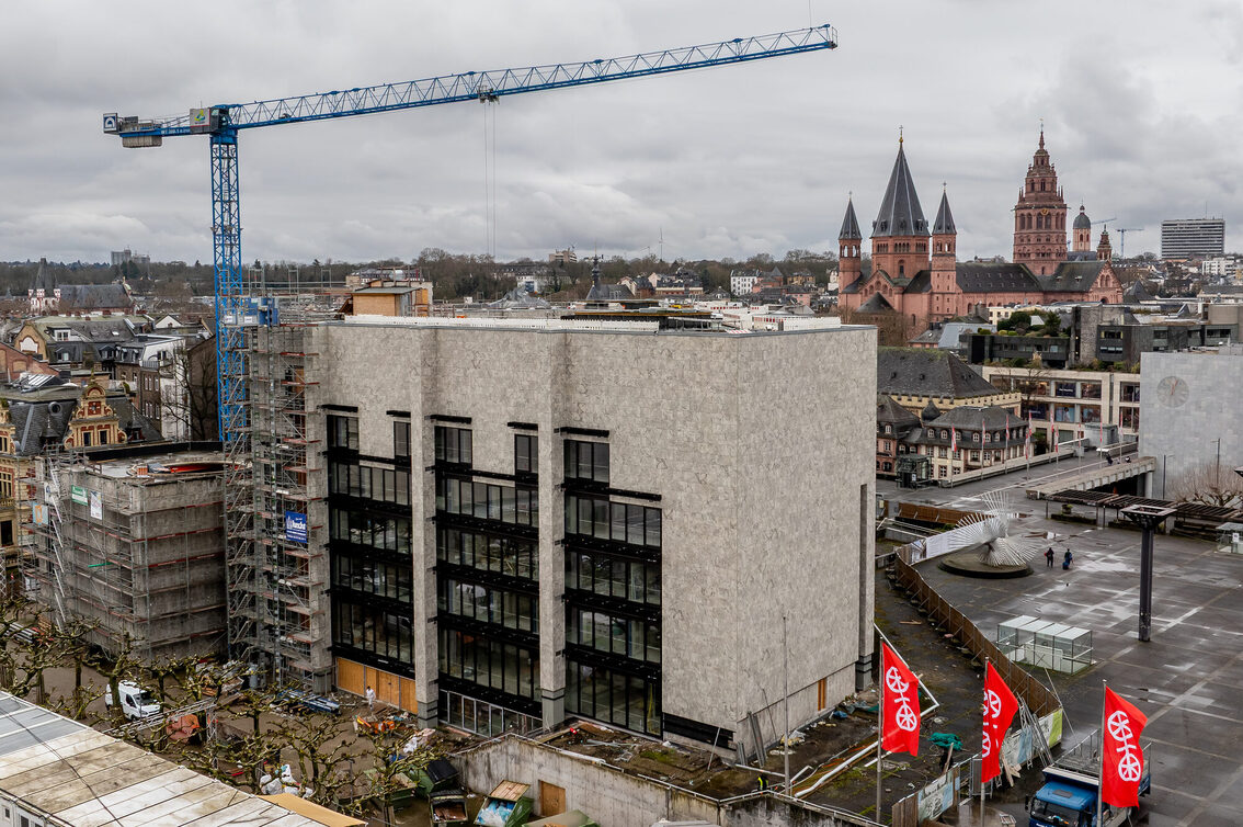 Vor dem Rathausgebäude steht ein Kran, im Hintergrund ist der Mainzer Dom zu sehen