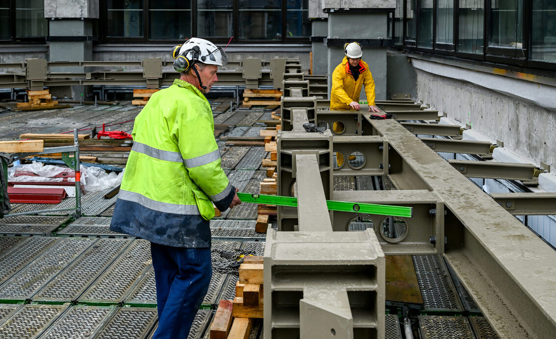 Zwei Bauarbeiter bei der Arbeit auf der Baustelle des Rathauses
