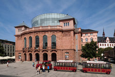 Bildergalerie Staatstheater Staatstheater mit Touristik-Bahn Die heutige Baugestalt basiert im wesentlichen auf der Erweiterung durch Stadtbaurat Adolf Gelius, der von 1910 bis 1912 den Foyer-Vorbau und seitliche Treppenhäuser ergänzte.