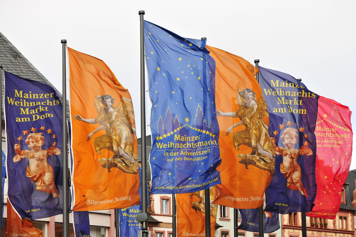 Die Fahnen auf dem Mainzer Weihnachtsmarkt wehen im Wind