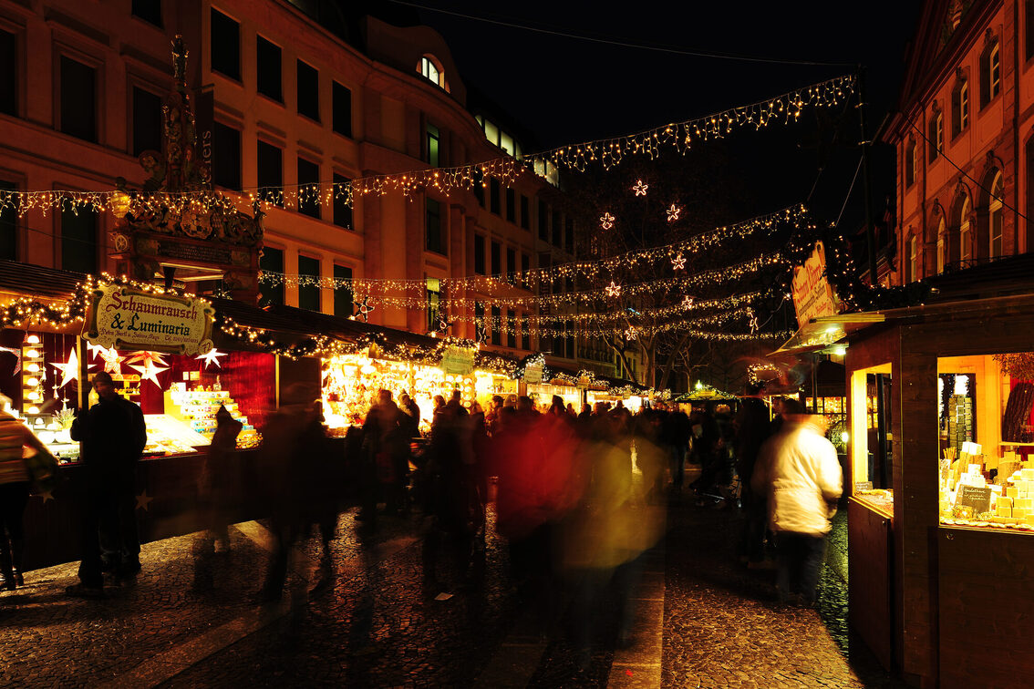 Weihnachtsmarktbuden, Lichterketten und Passanten