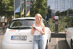 Junge Frau bucht ein Carsharing Auto © book-n-drive Carsharing