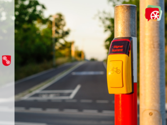 Foto Anforderungstaster für Fahrräder an Ampel vor Straße im Sonnenlicht