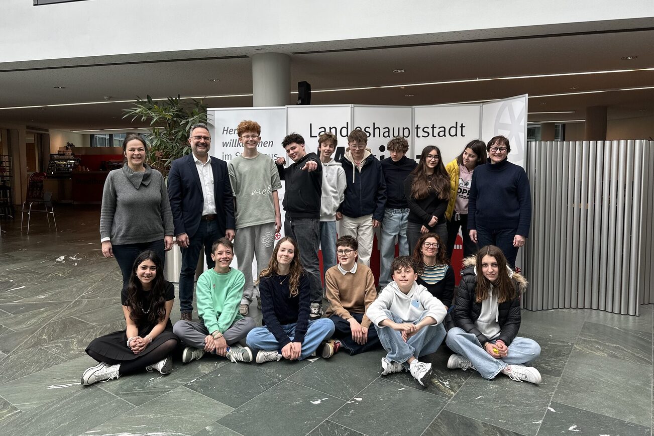 Group of people in the foyer of Mainz Town Hall: one teacher on the left, one on the right. Second person from the left: head of the school department Delbasteh. In between 14 exchange students