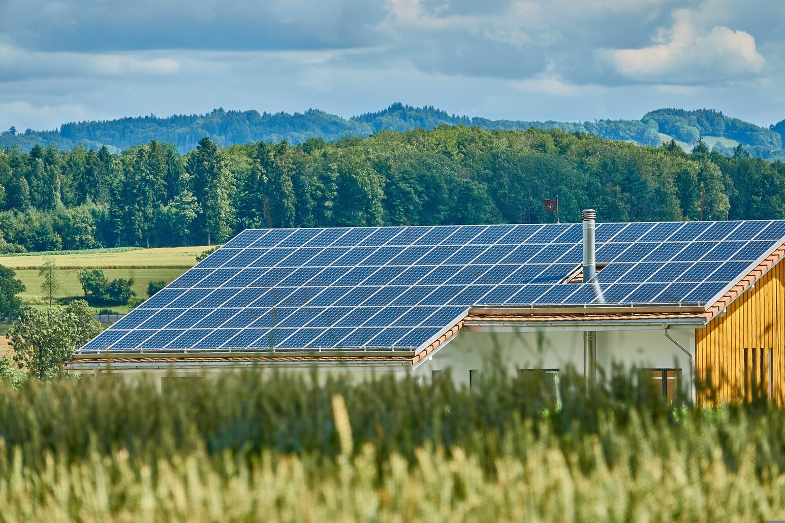 Maison avec panneaux solaires dans un paysage verdoyant