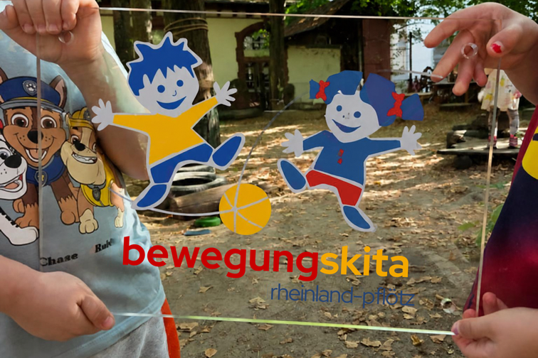Targhetta di riconoscimento “bewegungskita rheinland-pfalz”, tenuta tra le mani dei bambini