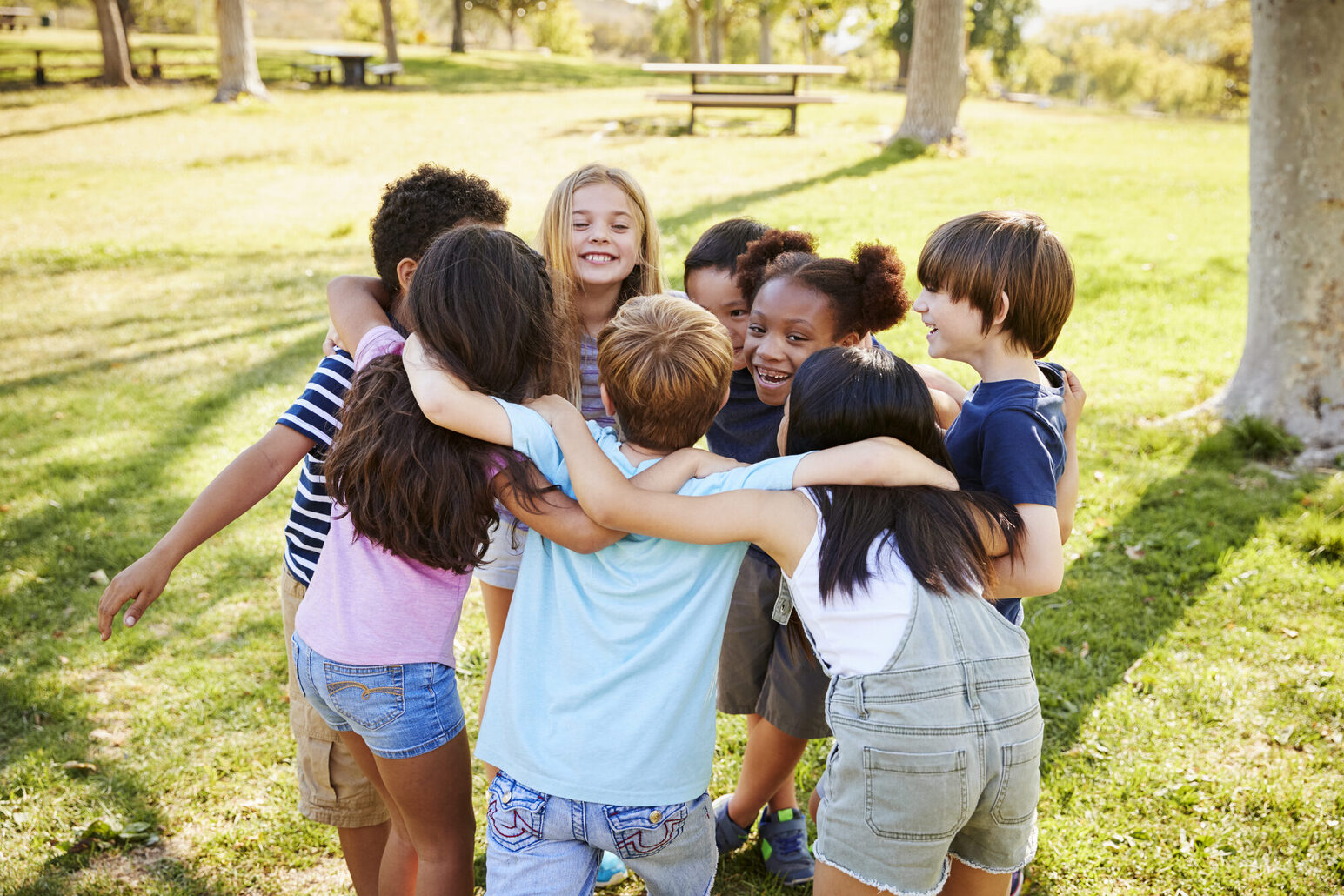 A group of children hug each other.