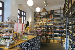 Thomas Keßler in seiner Vinothek, im Hintergrund Weinflaschen im Regal © Landeshauptstadt Mainz