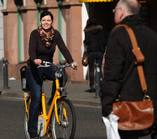 Blinkender Anforderungstaster für Radfahrende. Fahrradstraße verschwommen.