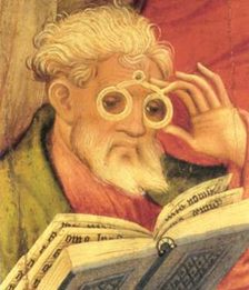 Das Bild zeigt einen Brillenträger, der ein Buch liest.