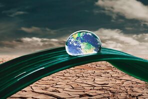 Bild der Weltkugel als Wassertropfen auf einem grünen Blatt in der Wüste &copy; Pixabay