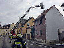 Löscharbeiten mithilfe der Drehleiter am Schornstein des Hauses.