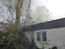 Rauch steigt über dem Dach des Hauses auf.