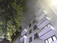 Rauch dringt aus einem Fenster des Wohnhauses.