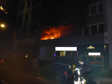 Ein brennender Balkon eines Mehrfamilienhauses.