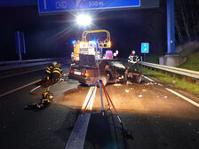 Einsatzkräfte am Unfallfahrzeug.