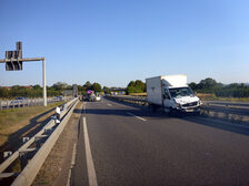 Demolierter Transporter an der Unfallstelle, Einsatzkräfte im Hintergrund.