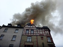 Flammen dringen aus dem Dachstuhl aus.