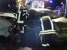 Einsatzkräfte arbeiten am Unfallfahrzeug.