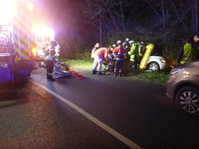 Einsatzkräfte am Unfallfahrzeug.
