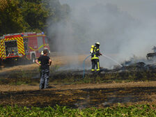 Einsatzkräfte bei Löscharbeiten auf dem Feld.