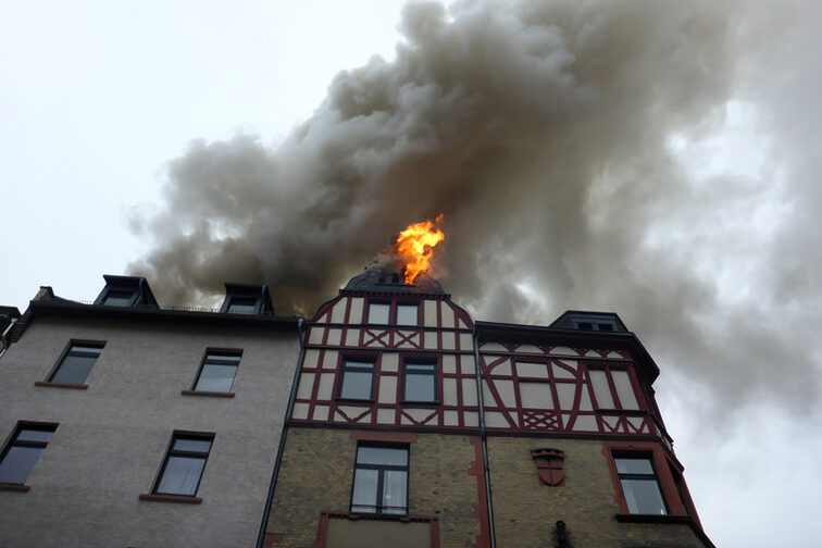 Flames are leaking out of the roof truss.