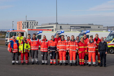 Einsatzkräfte verschiedener Hilfsorganisationen vor Einsatzfahrzeugen