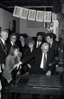 Michail Gorbatschow druckt eine Bibelseite.