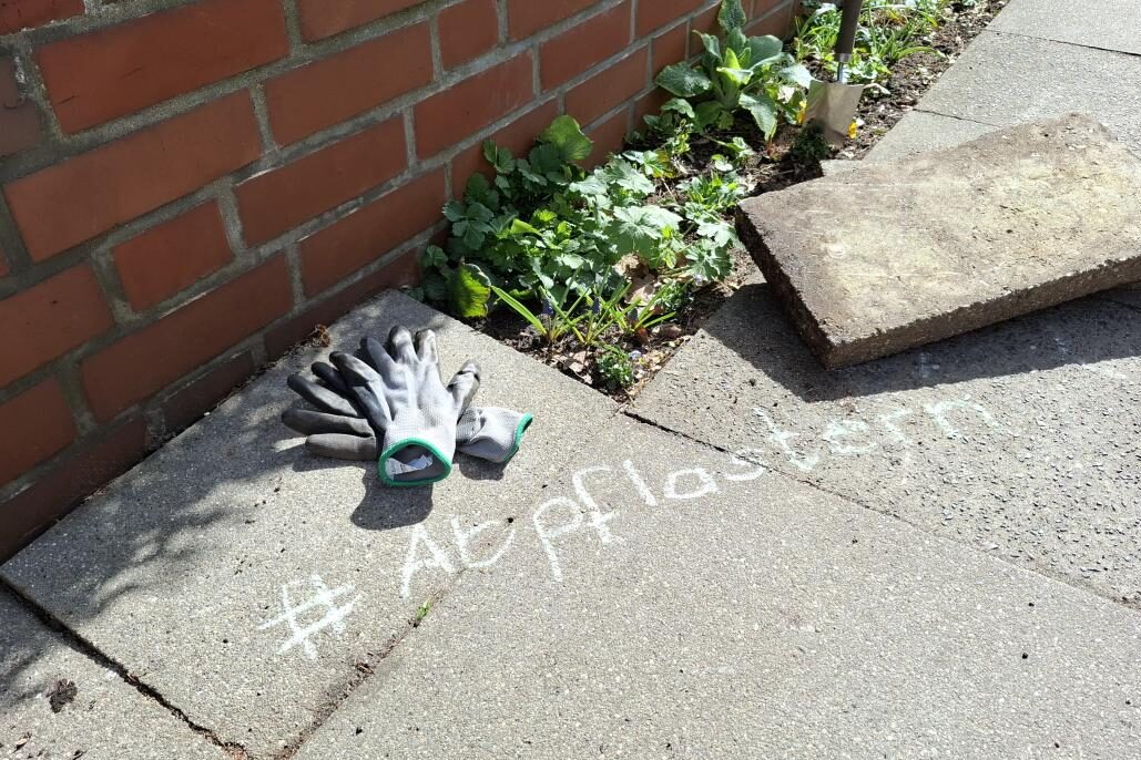 Auf Asphalt steht mit Kreide "Abpflastern"