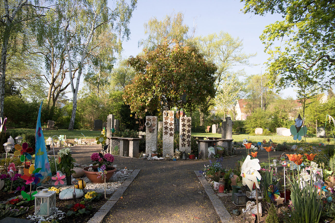 Sternförmige Namensschilder am gemeinschaftlichen Grabmal