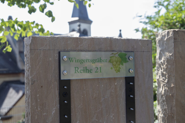 Blick auf eine neue Stele mit Hinweisschild Wingertsgräber