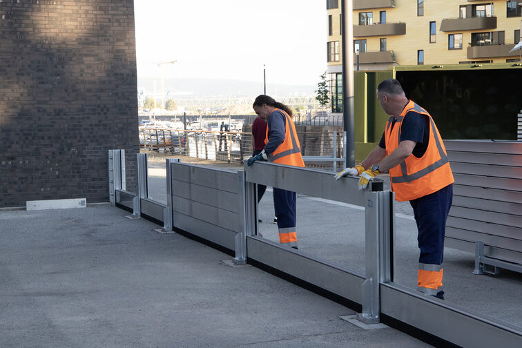 Das Bild zweigt wie zwei Mitarbeiter die Wandbalken einsetzen